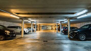 A multi-level parking garage with concrete pillars and overhead lighting.