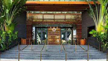 A modern building entrance with a sign reading 'DIPLOMAT BEACH RESORT'.