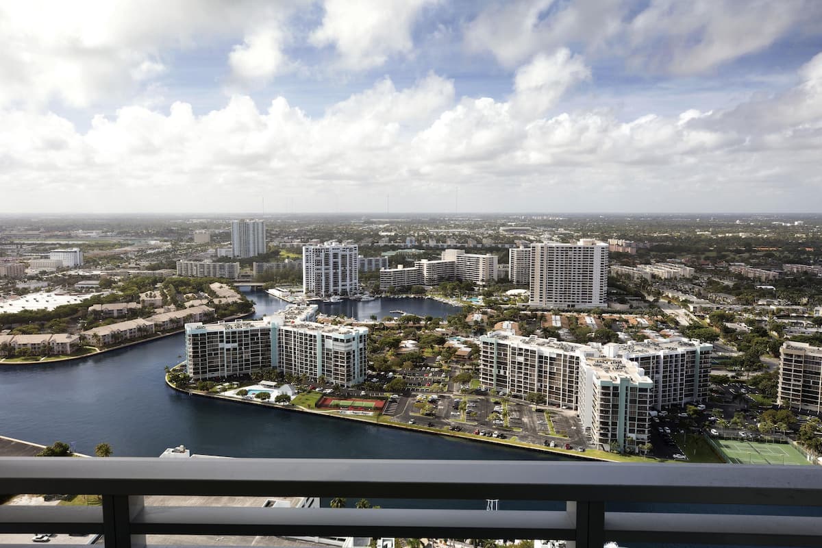 A high-rise building with a view of a river and surrounding cityscape.