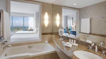 Un baño de hotel con una bañera grande, un lavabo y un espejo.