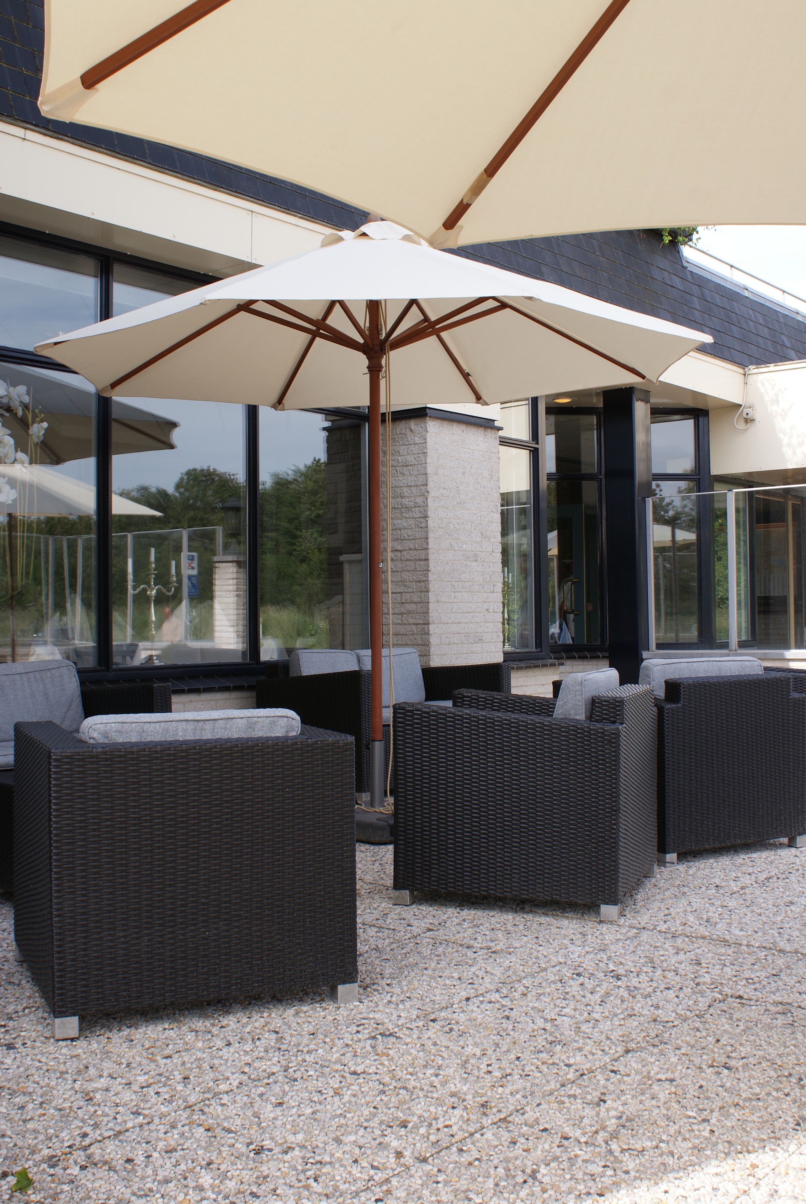 An outdoor seating area with wicker furniture and a large umbrella.