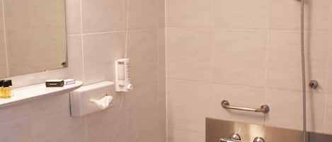 Baño con lavamanos, espejo y bañera con ducha.