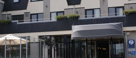 A modern hotel with a curved entrance, a satellite dish, and a sign indicating a 2-star rating.