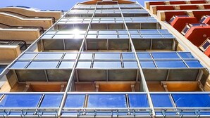 A hotel entrance with a large glass facade, a sign reading "HOTEL KENNEDY NOVA," and a reflection of the sky and other buildings. - Hotel Kennedy Nova (Gzira)
