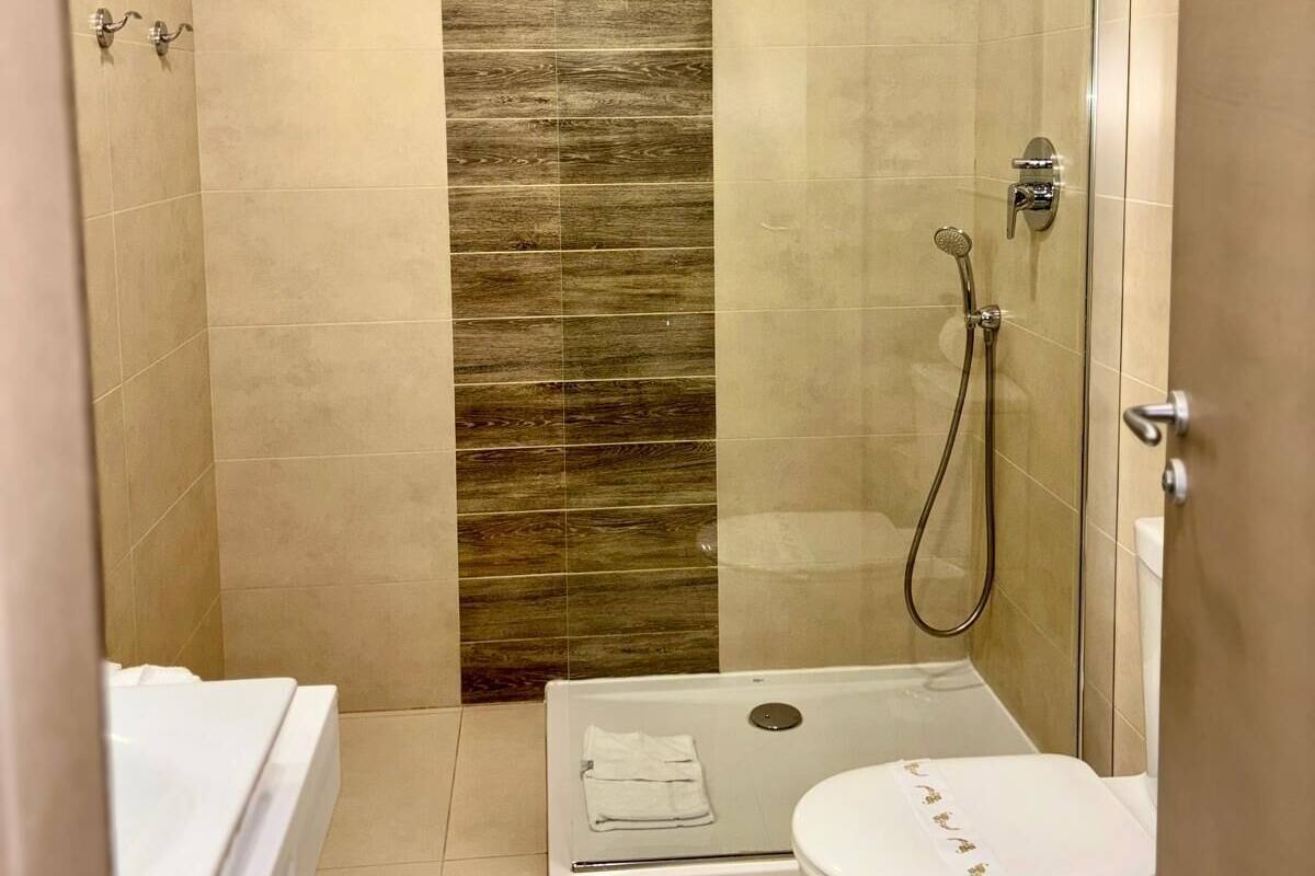 A small bathroom with a shower, toilet, and a bathtub.