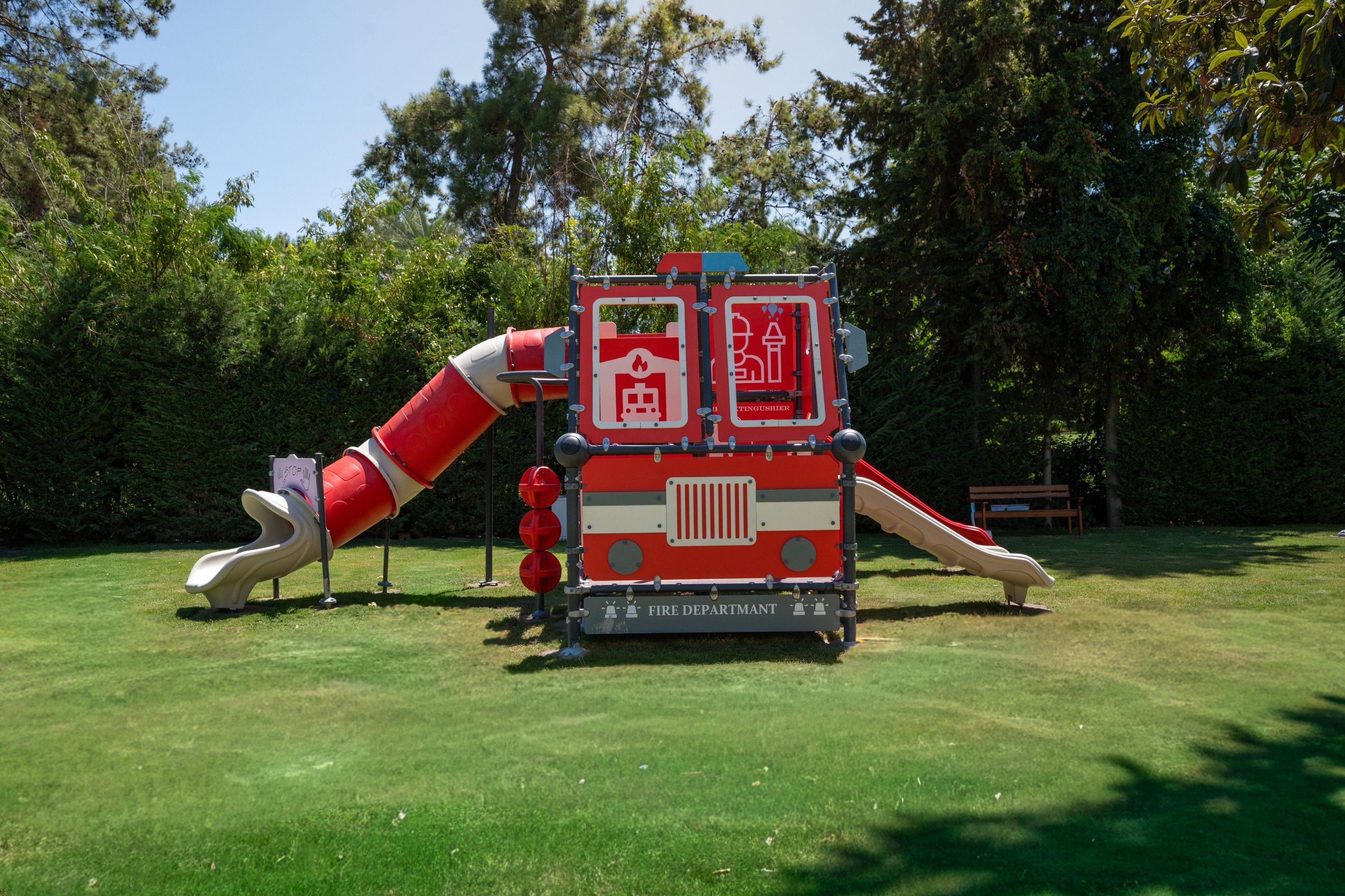 A playground with a slide and a fire department-themed play structure.