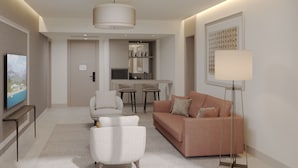 A modern living room with a sofa, armchairs, a coffee table, a TV, and a desk with a chair. -  Mirage Park Resort - Premium All Inclusive (Kemer)