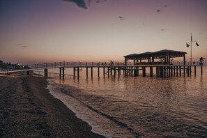A pier extending into calm waters with a covered seating area. -  Mirage Park Resort - Premium All Inclusive (Kemer)