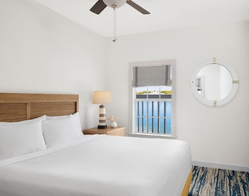 A modern kitchen with blue cabinets, stainless steel appliances, and a dining area with a table and chairs. at Hyatt Vacation Club at Beach House, Key West