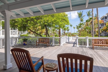 A spacious living area with a large window, a dining table, and comfortable seating. at Hyatt Vacation Club at Beach House, Key West