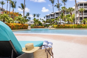 A wooden deck with two wooden chairs and a small table, surrounded by white railings and palm trees. at Hyatt Vacation Club at Beach House, Key West