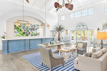 A modern kitchen with blue cabinets, a stainless steel refrigerator, and a dining area with wicker chairs. at Hyatt Vacation Club at Beach House, Key West
