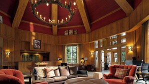 A spacious lodge with a high ceiling, wooden beams, a chandelier, leather furniture, and large windows. - The Residences at Mountain Lodge, Beaver Creek by Hyatt Vacation Club (Avon)