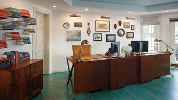 A spacious office with a wooden desk, bookshelves, and various framed pictures on the walls.