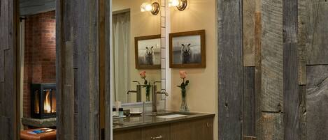 A wooden-framed doorway leading to a bathroom with a mirror, sink, and towel rack.