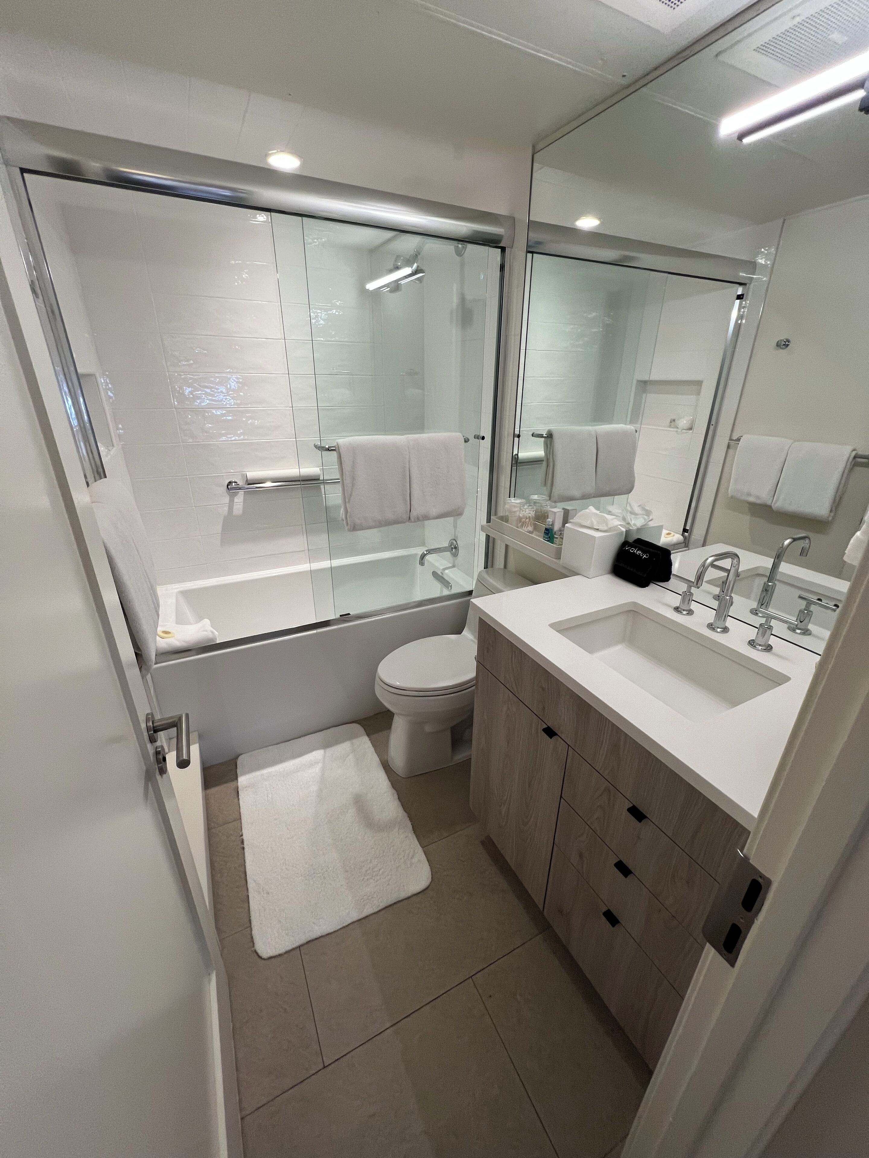 A modern bathroom with a glass-enclosed shower, a toilet, a sink, and a vanity.