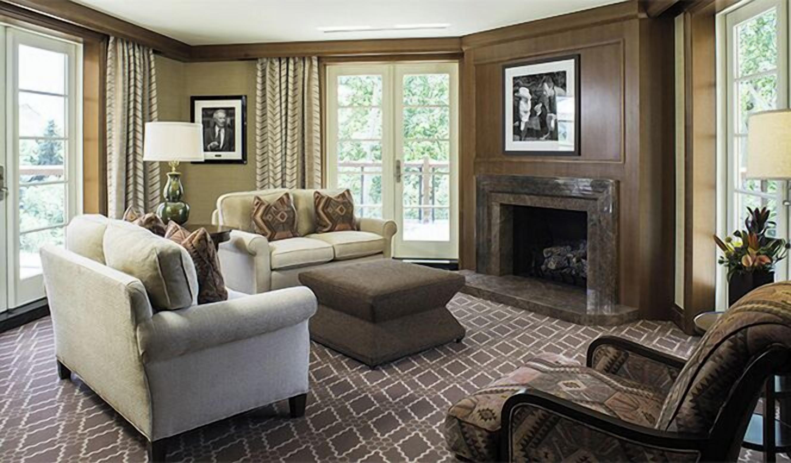 A living room with a fireplace, a sofa, a chair, and a patterned rug.