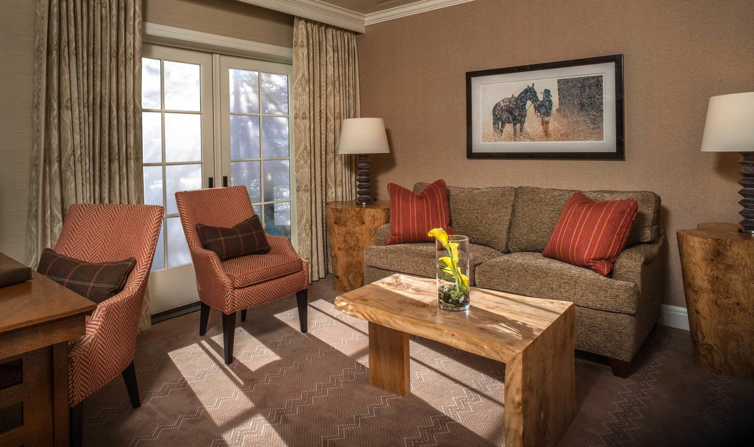 A living room with a sofa, two armchairs, a coffee table, and a framed picture on the wall.