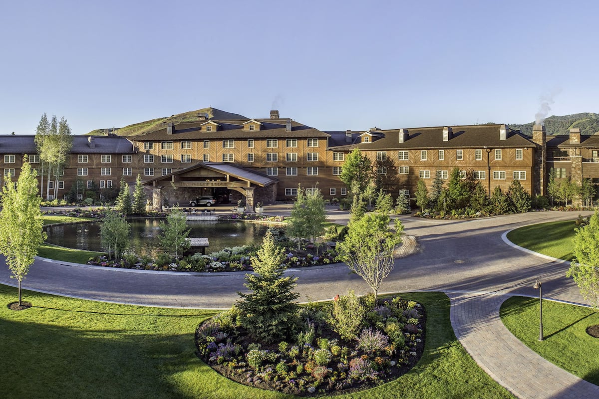 A large hotel with multiple buildings, a central courtyard with a pond, and surrounding landscaped gardens.