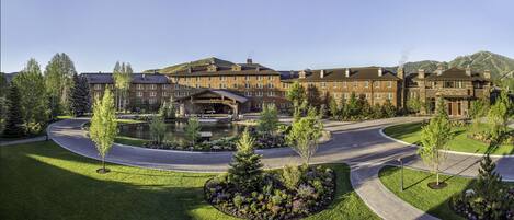 A large hotel with multiple buildings, a central courtyard with a pond, and surrounding landscaped gardens.