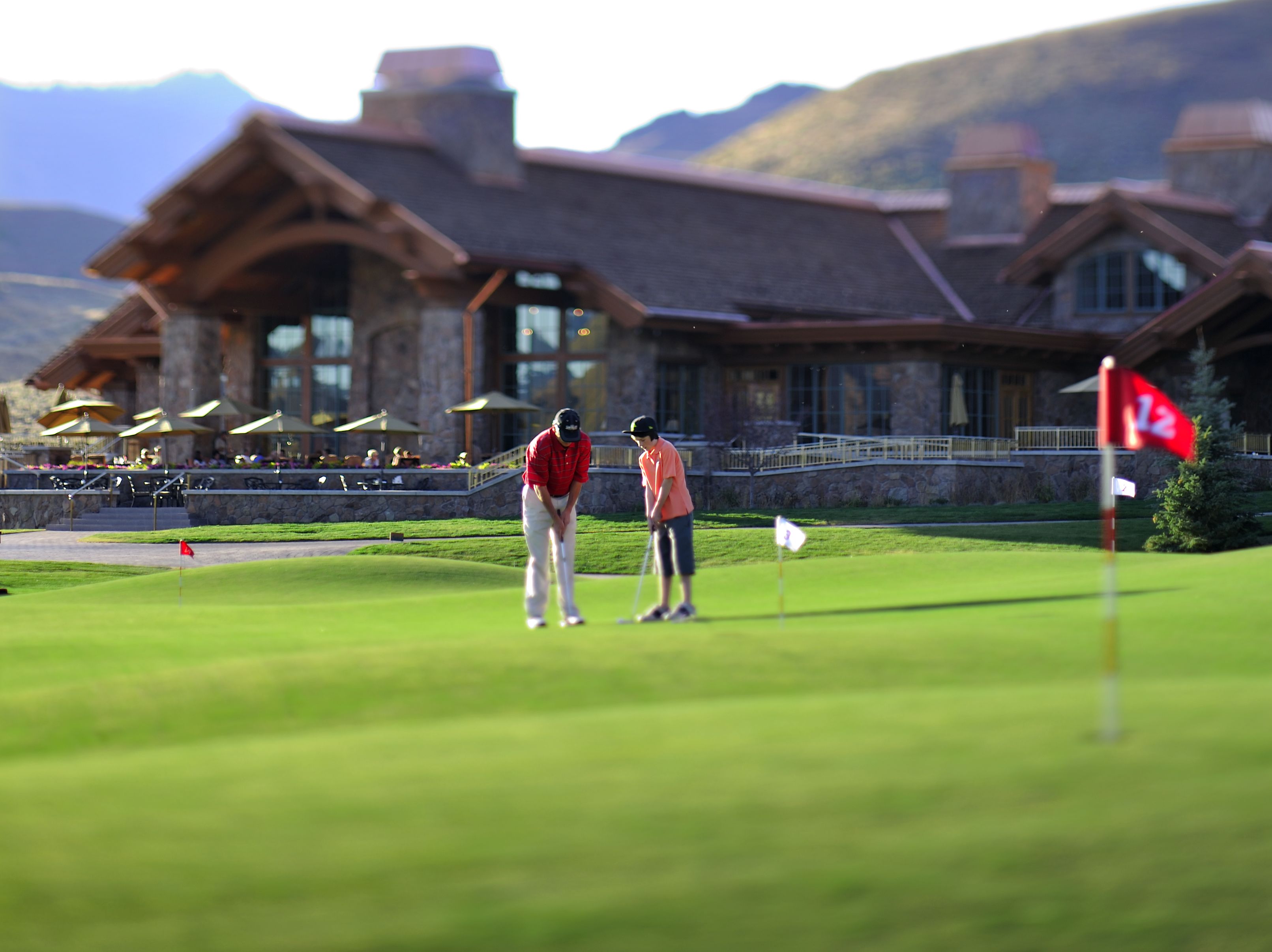 Camp de golf amb una casa de logis al fons.