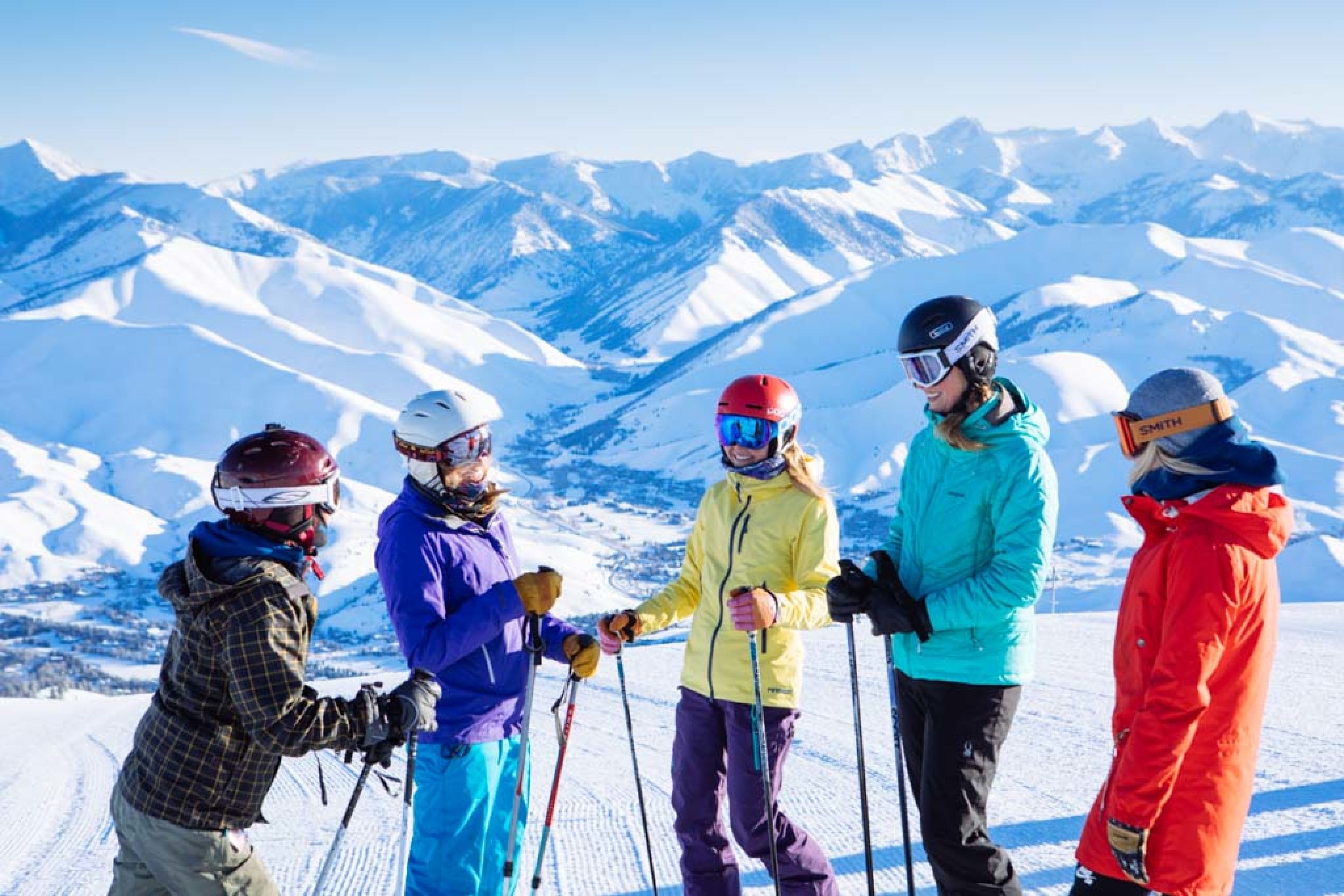 Un groupe de skieurs sur une montagne enneigée, sous un ciel dégagé.