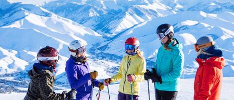 Un groupe de skieurs sur une montagne enneigée, sous un ciel dégagé.