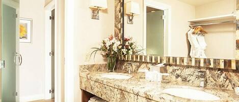 Un baño con dos lavamanos, un espejo grande y un florero con flores.