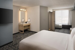 A hotel room with a bed, a bathroom with a sink and mirror, and a window with curtains. - Hyatt Place Bentonville/Rogers (Rogers)
