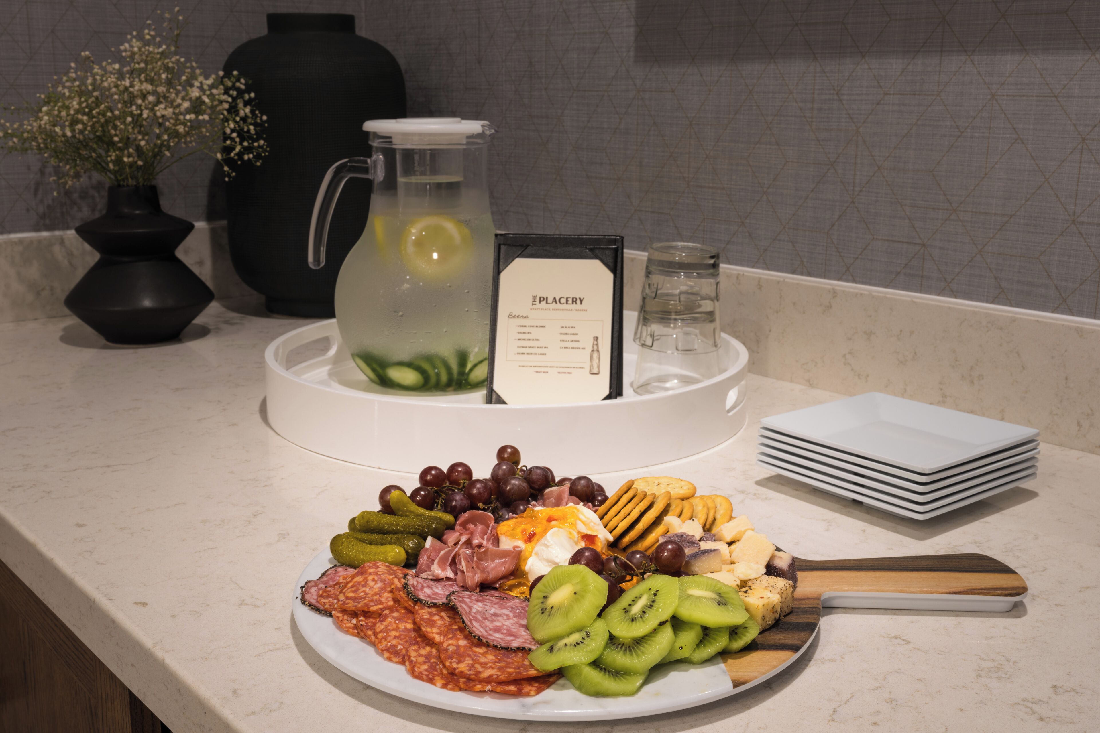 Une table de buffet proposant une variété d’aliments, notamment des viandes, des fromages et des fruits.