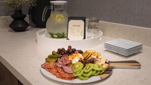 Une table de buffet proposant une variété d’aliments, notamment des viandes, des fromages et des fruits.