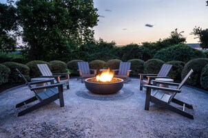 Un hogar rodeado de sillas Adirondack en un entorno al aire libre.