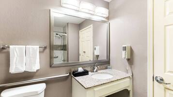 A bathroom with a sink, mirror, towel rack, and a hand dryer.