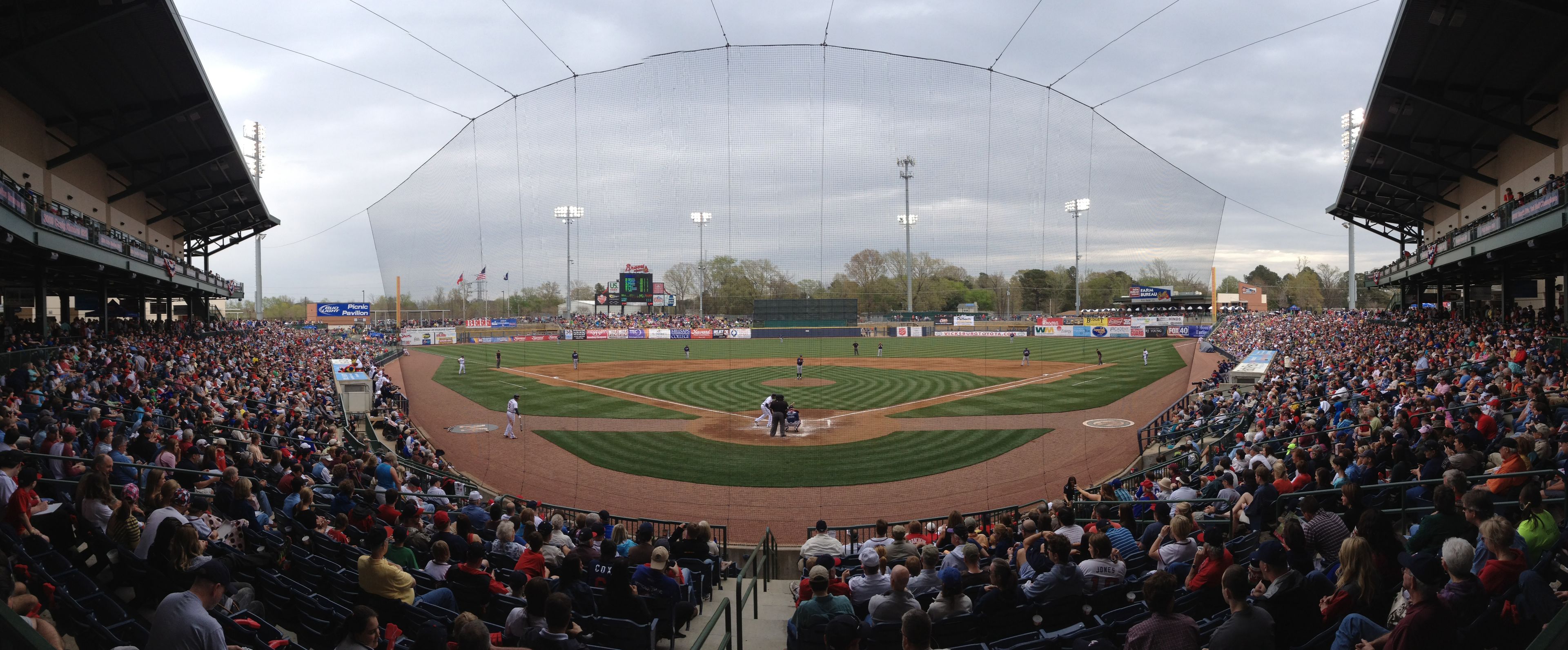 A baseball stadium with a large seating capacity, a central field, and multiple advertising banners.