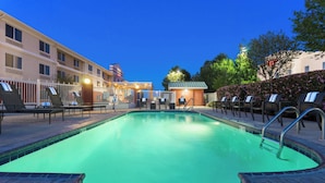 A swimming pool with lounge chairs and a small building in the background. - Fairfield Inn & Suites Odessa (Odessa)