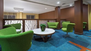 A conference room with a round table, green chairs, a potted plant, and a blue carpet. - Fairfield Inn & Suites Odessa (Odessa)