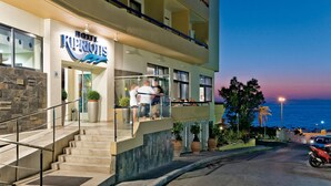 A hotel with a prominent sign, a staircase leading to the entrance, and a view of the ocean at dusk. - Rhodos Horizon Blu (Rhodes)