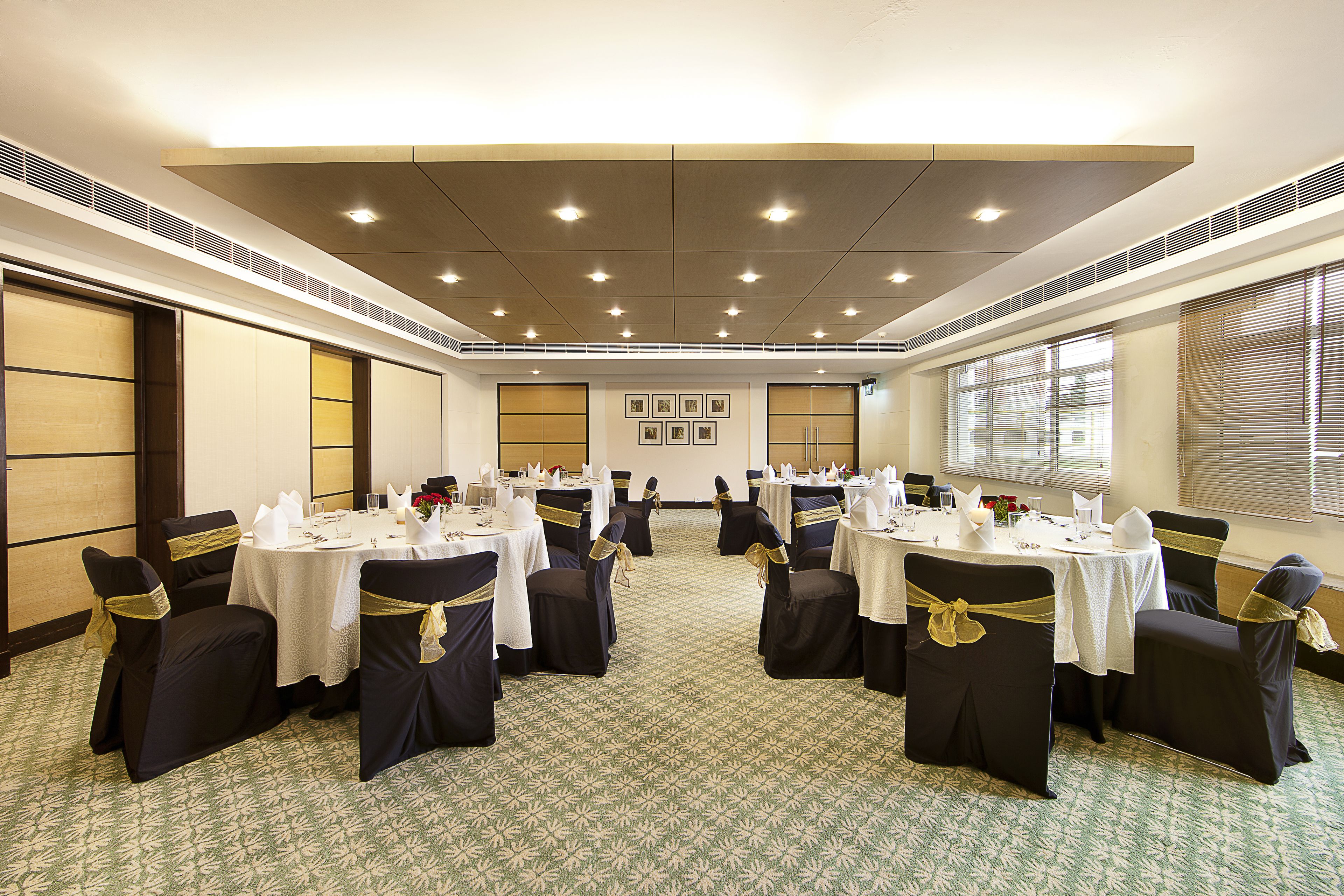 A conference room with round tables and chairs, equipped with nameplates and table settings.