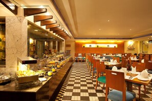 Un buffet proposant une grande variété de plats, avec un sol à motifs à carreaux.