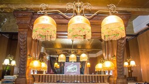 A grand lobby with ornate chandeliers and a large screen. - Van Gilder Hotel (Seward)