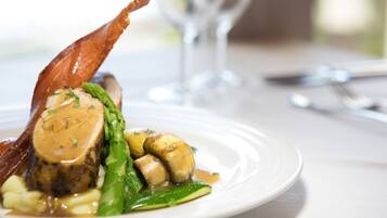 Une assiette contenant un plat composé d’une portion de viande, de légumes et de sauce.