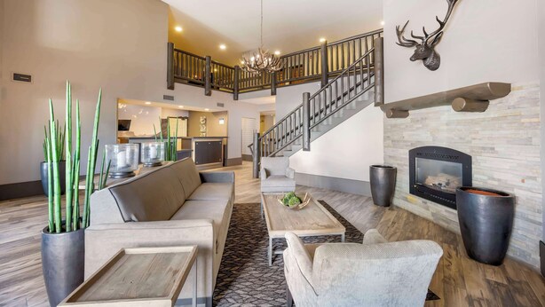 A spacious living area with a modern fireplace, a staircase, and a dining area.