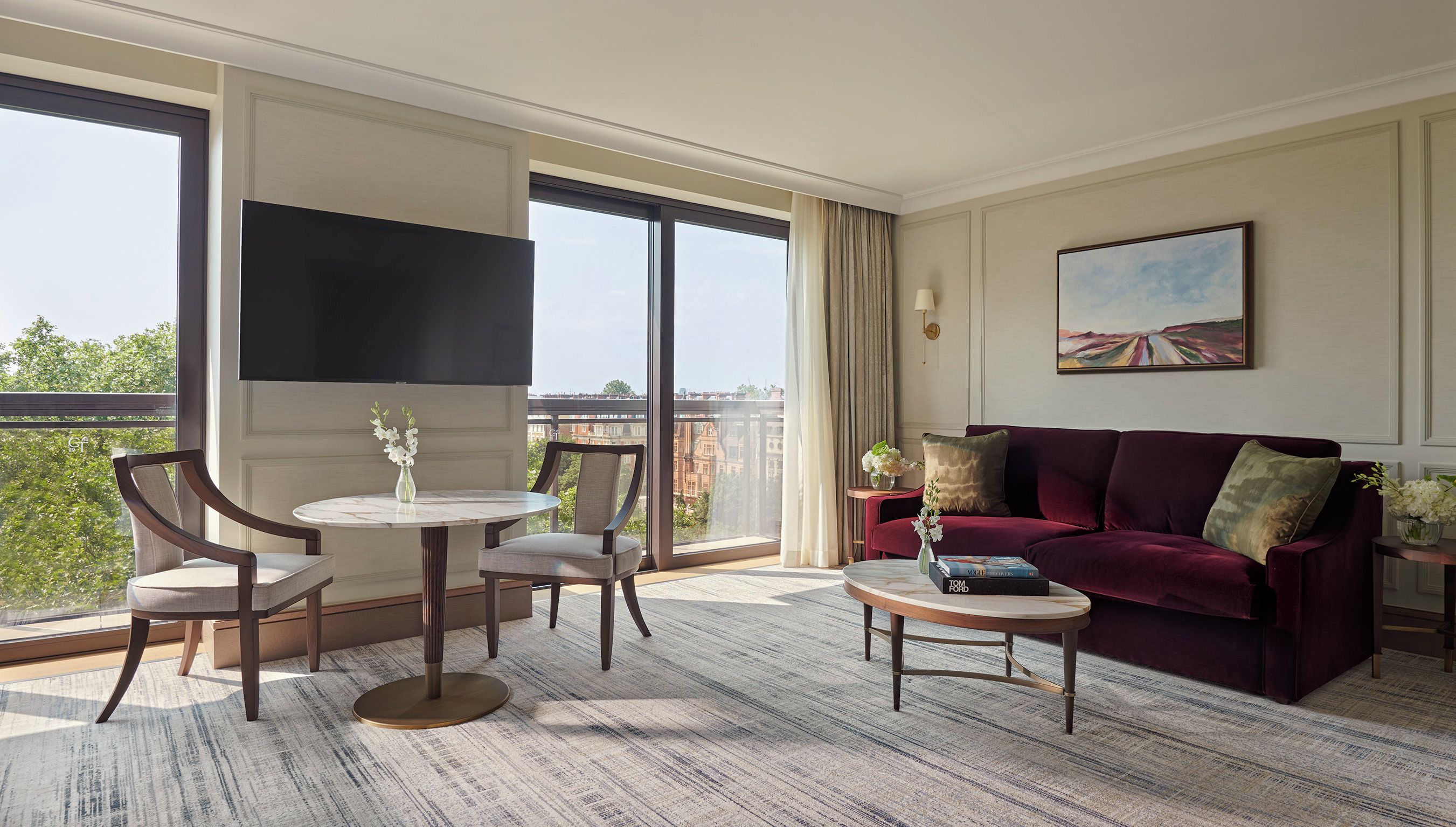 Une chambre d’hôtel avec une grande fenêtre, un canapé, une table basse et un téléviseur.