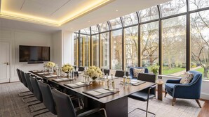 A conference room with a long table, chairs, and a TV. - Jumeirah Carlton Tower London (London)