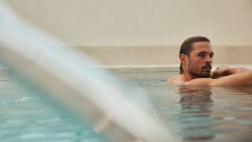 A person in a hot tub with a blurred background.