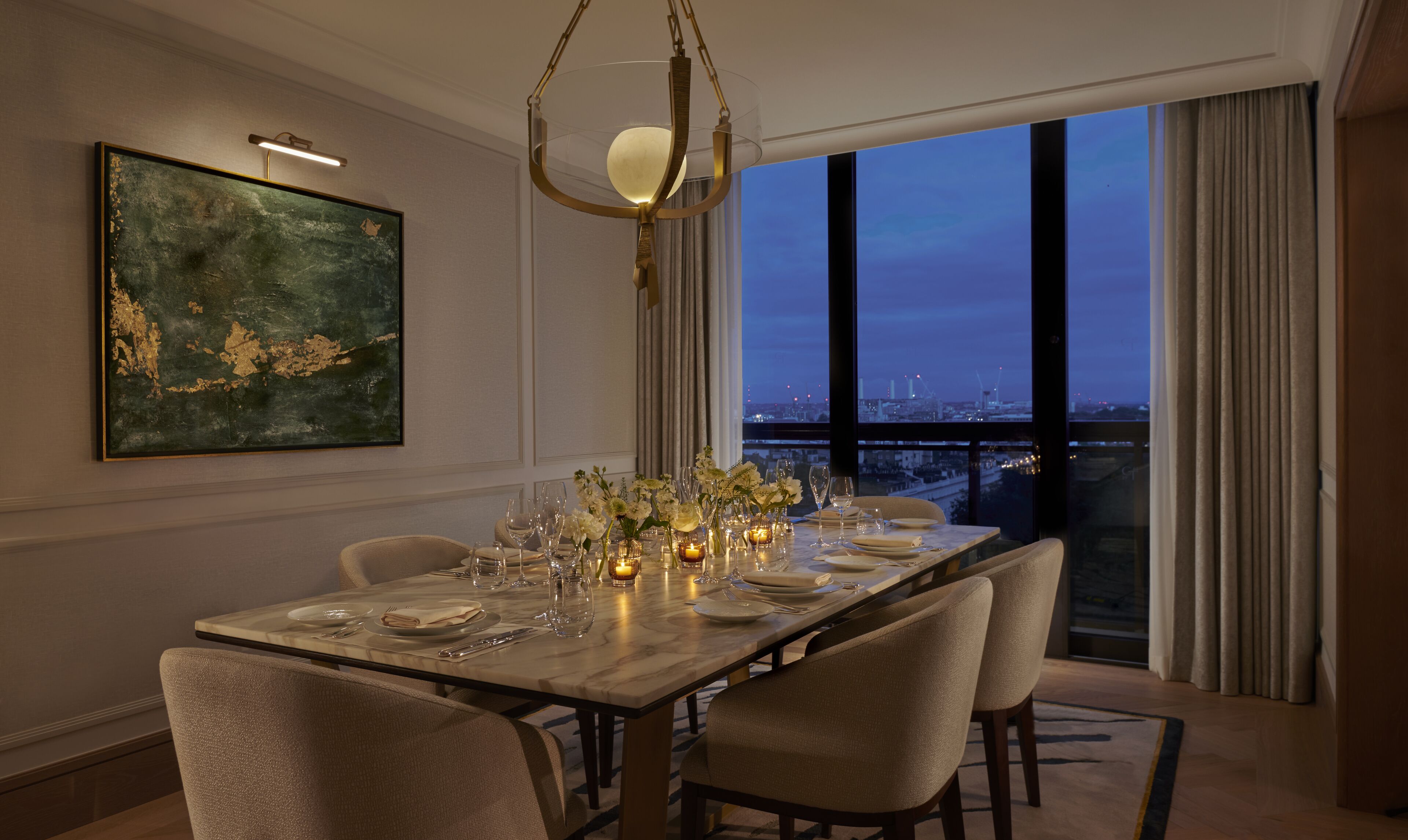 A dining area with a table set for four, a chandelier, and a large window with a city view.