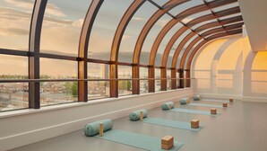 A spacious room with large windows, yoga mats, and wooden blocks arranged for a yoga session. - Jumeirah Carlton Tower London (London)