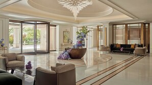 A spacious lobby with a large central table, seating arrangements, and a grand chandelier. - Jumeirah Carlton Tower London (London)