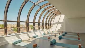 A spacious room with large windows and a view of the cityscape.