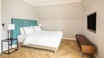 Un dormitorio con cama, mesita de noche, televisor y banco de madera.